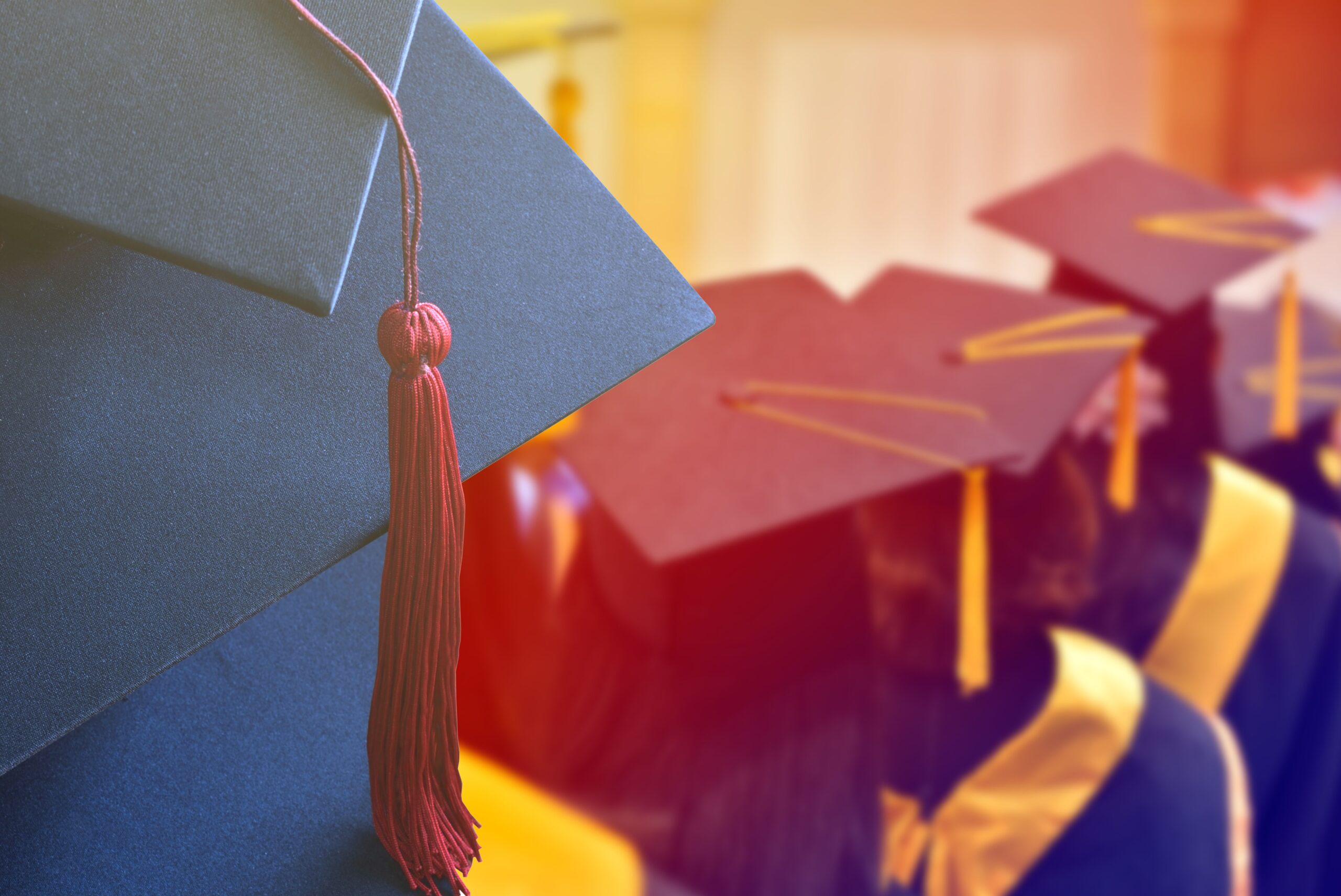 Black graduation caps with maroon tassels prominently display the celebratory moment of a graduation ceremony, capturing the focus on achievement.